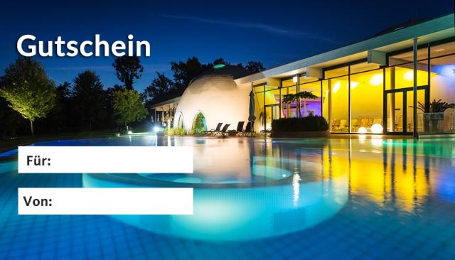 Stimmungsvoll beleuchteter Außenpool mit Therme im Hintergrund